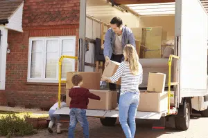 Family of three loading up moving truck. 