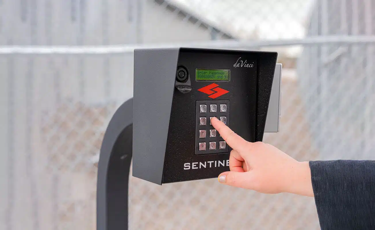 hand pushing numbers on gate access pad