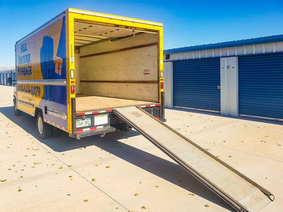 Back of moving truck with door rolled up and ramp extended